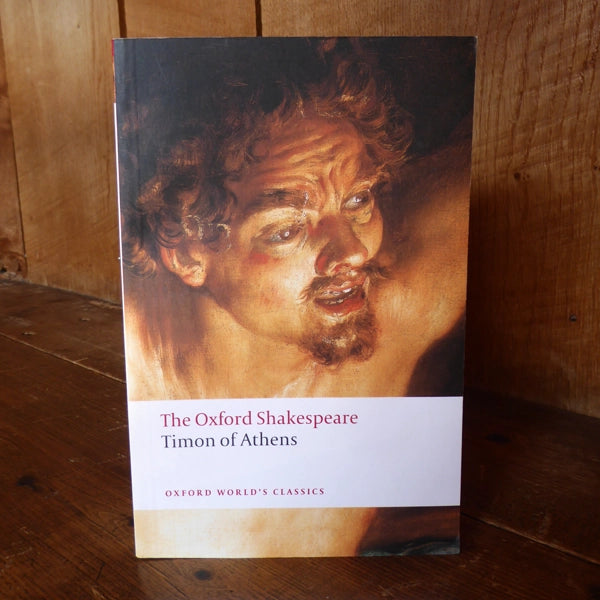 Paperback book with image of upper torso and head of a man with curly hair, thick eyebrows and a beard