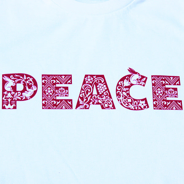 
                  
                    White t-shirt with a red patterned print on the chest that reads PEACE
                  
                