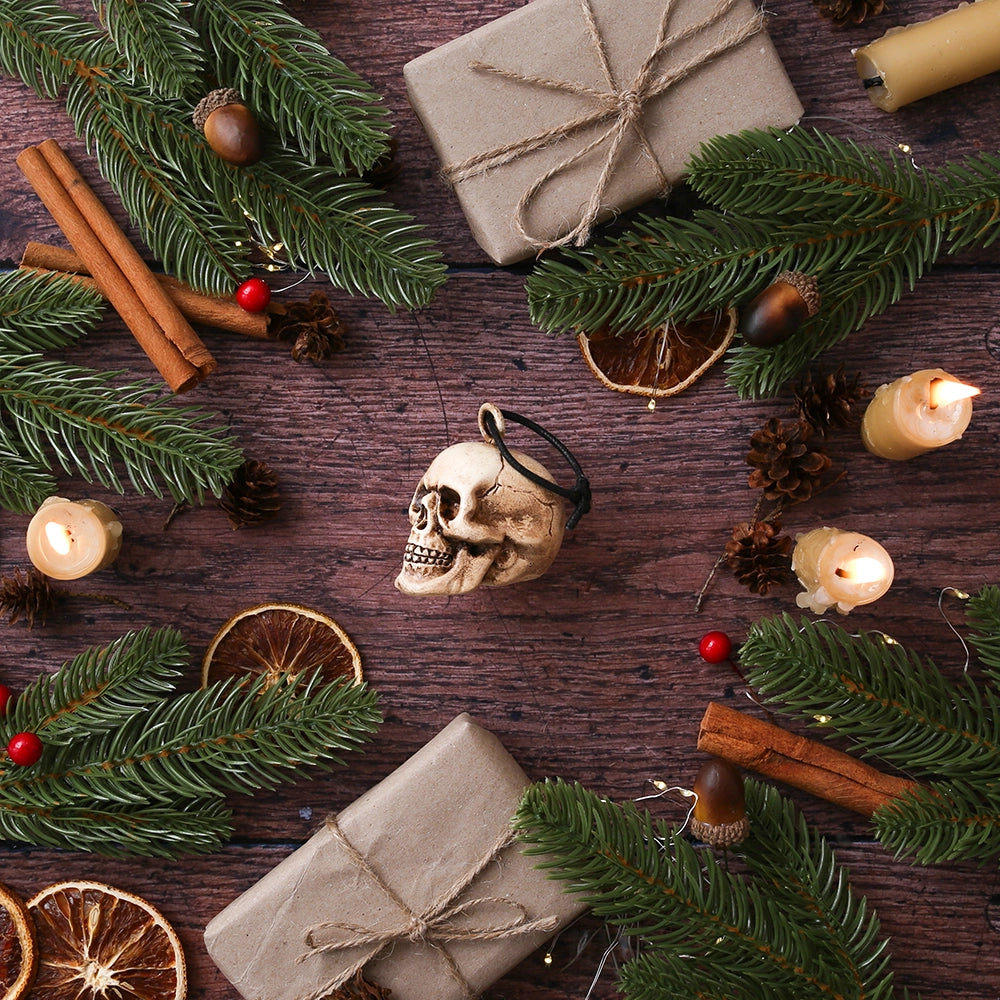 
                      
                        Plaster skull decoration, angled to the side, with rope tie, on wooden floor, surrounded by Christmas greenery
                      
                    