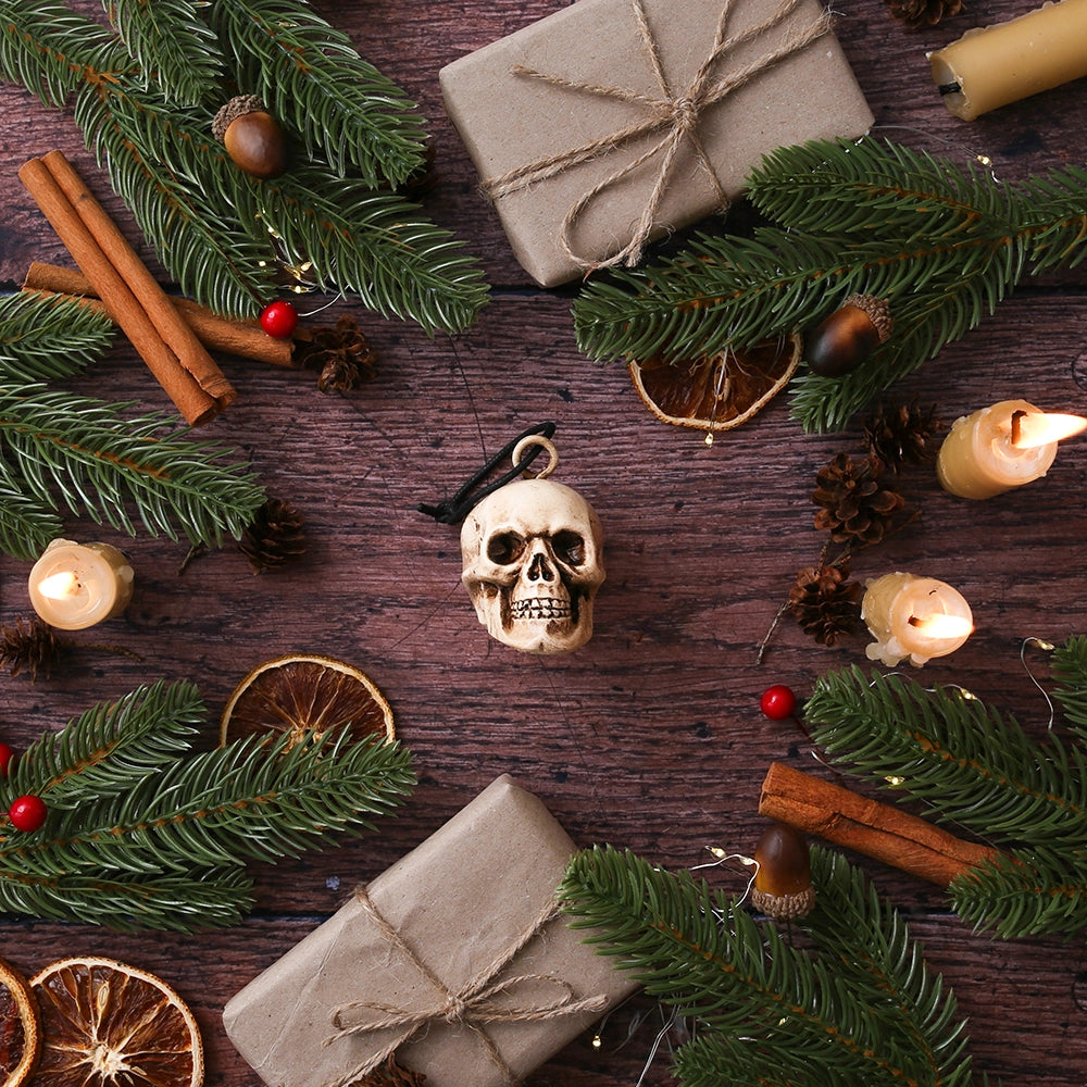 
                      
                        Plaster skull decoration with rope tie, on wooden floor, surrounded by Christmas greenery
                      
                    