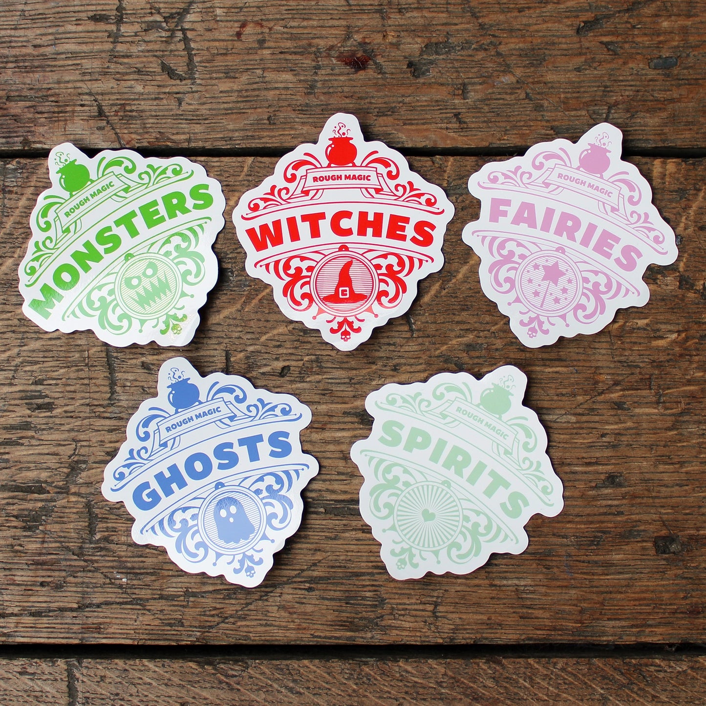 A collection of five white stickers with coloured motifs