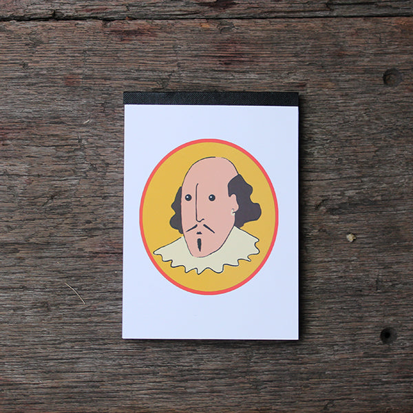 White paperback notepad with oval yellow graphic on centre front of cartoon William Shakespeare