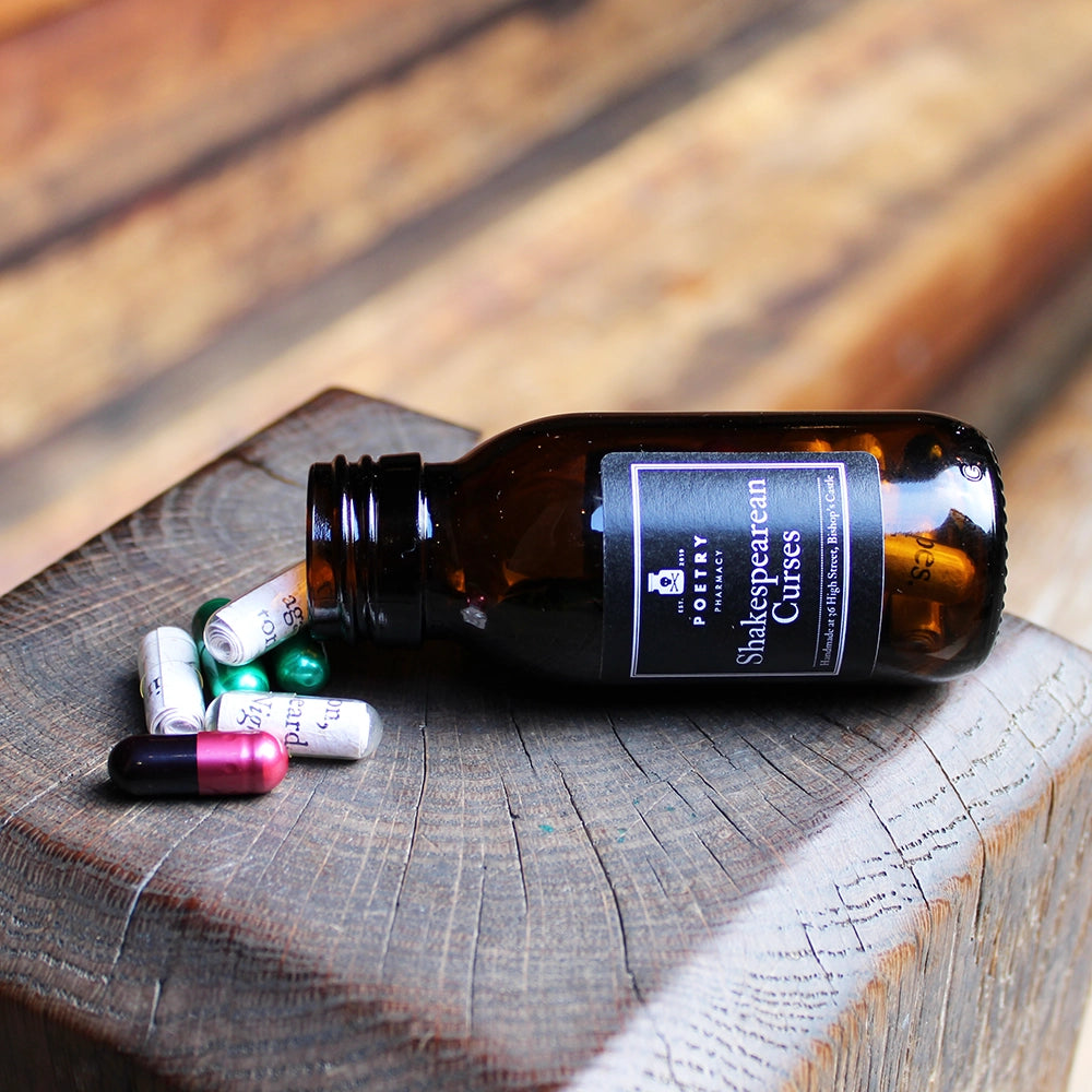 
                  
                    Brown pill bottle with black lid and black label with white writing on it, filled with multicoloured pill poems
                  
                