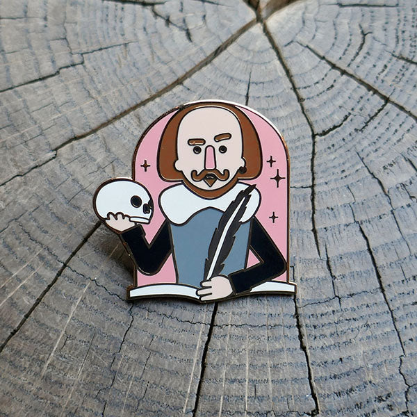 
                      
                        Cartoon metal pin badge of Shakespeare's torso with one hand holding a quill and the other a skull
                      
                    