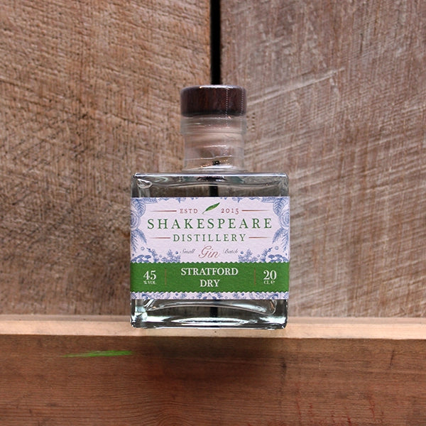Square glass bottle with white sticker with apple green banding at the bottom