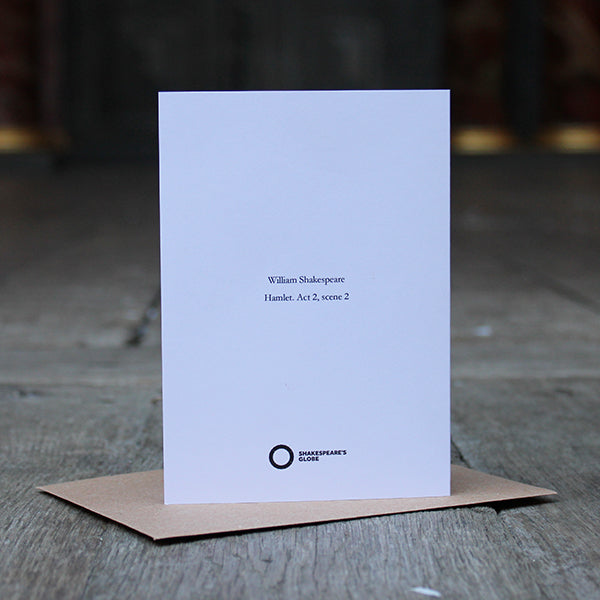 White hard paper card with central black text sitting on brown kraft envelope