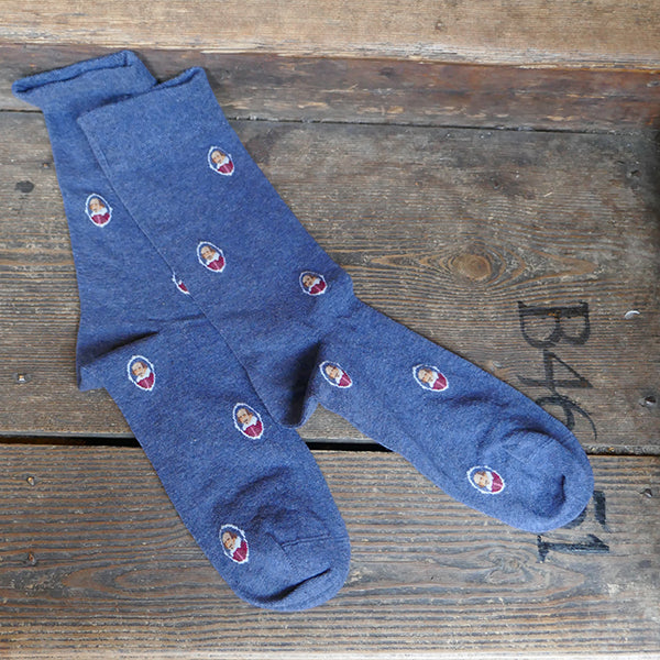 Mid blue socks with a repeating pattern of a portrait of William Shakespeare in a white oval.