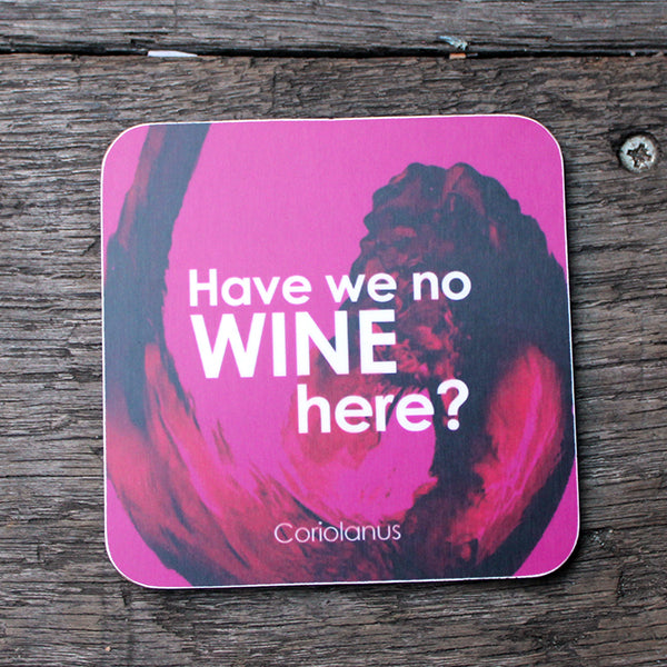 Pink coaster with sloshing red wine across it, featuring white graphic quote text