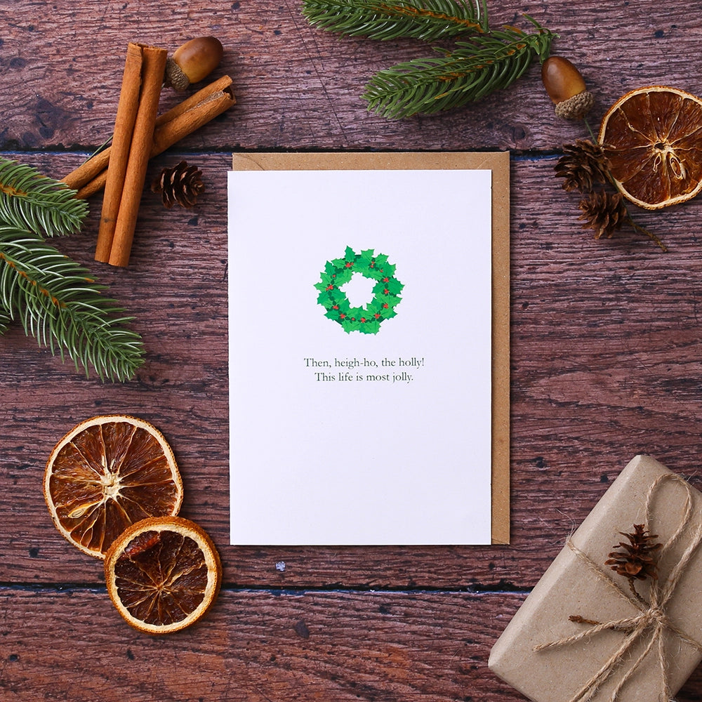 White card with a green holly wreath motif