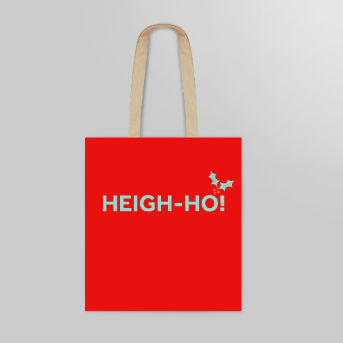 Bright red tote bag with natural handles. The bag is printed with a quote in light green  and a sprig of holly