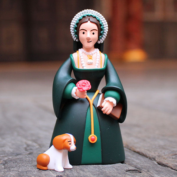 Figurine of a woman in historical attire holding a flower, with a dog at her feet, on a stone surface.