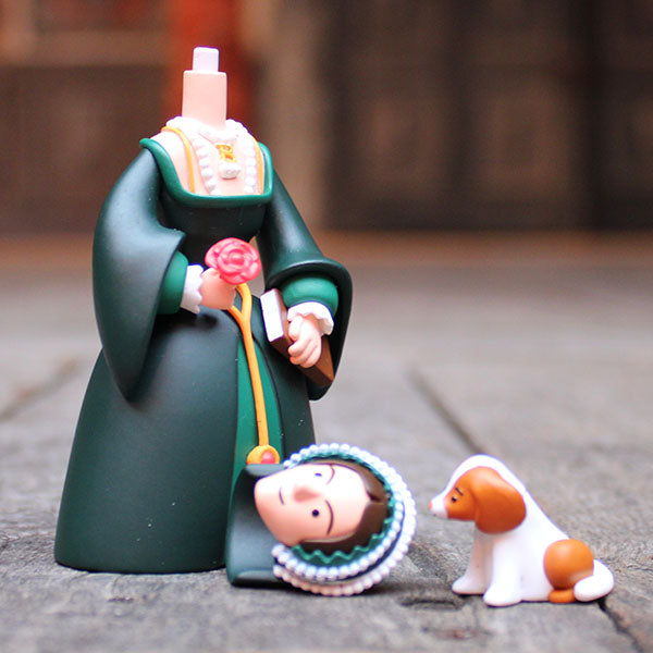 Decorative figurine of a headless woman with her head and dog on a wooden surface