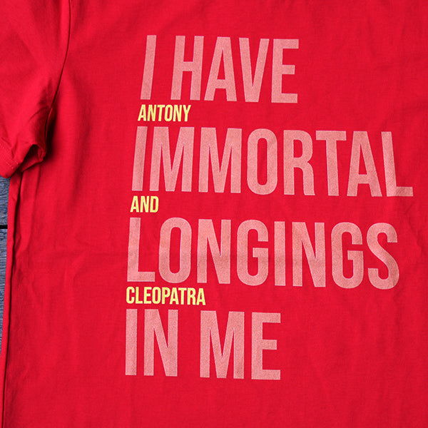 
                  
                    Red graphic t-shirt with pale orange and bright yellow graphic text aligned to the left
                  
                