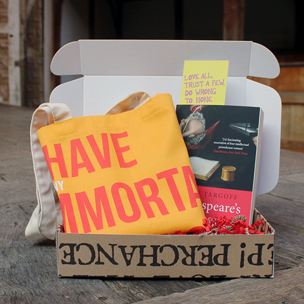 
                  
                    Kraft book box with stamped black writing, open, with yellow and red tote bag, red and black paperback book and yellow bookmark
                  
                