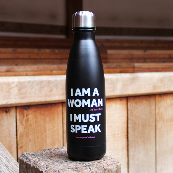 black metal water bottle with a silver cap and white text print standing on a wooden post