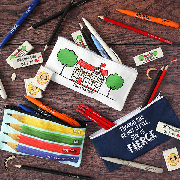 Natural wood panel floor with colourful Shakespeare themed pencil cases, erasers, pencils and pens strewn across it