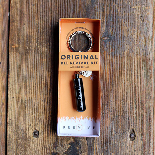 keyring with a black metal capsule attached in orange packaging