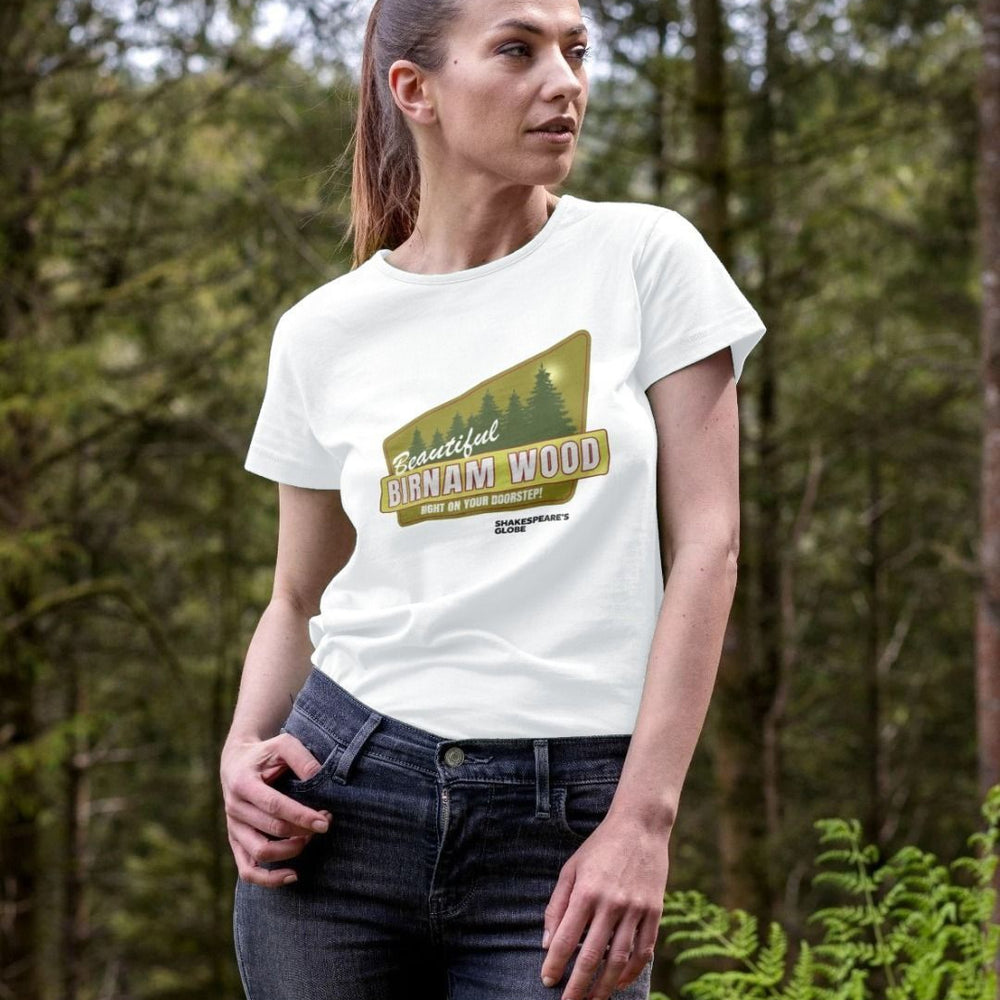 White fitted t-shirt with yellow and green vintage travel poster image of forest, with white graphic text over top