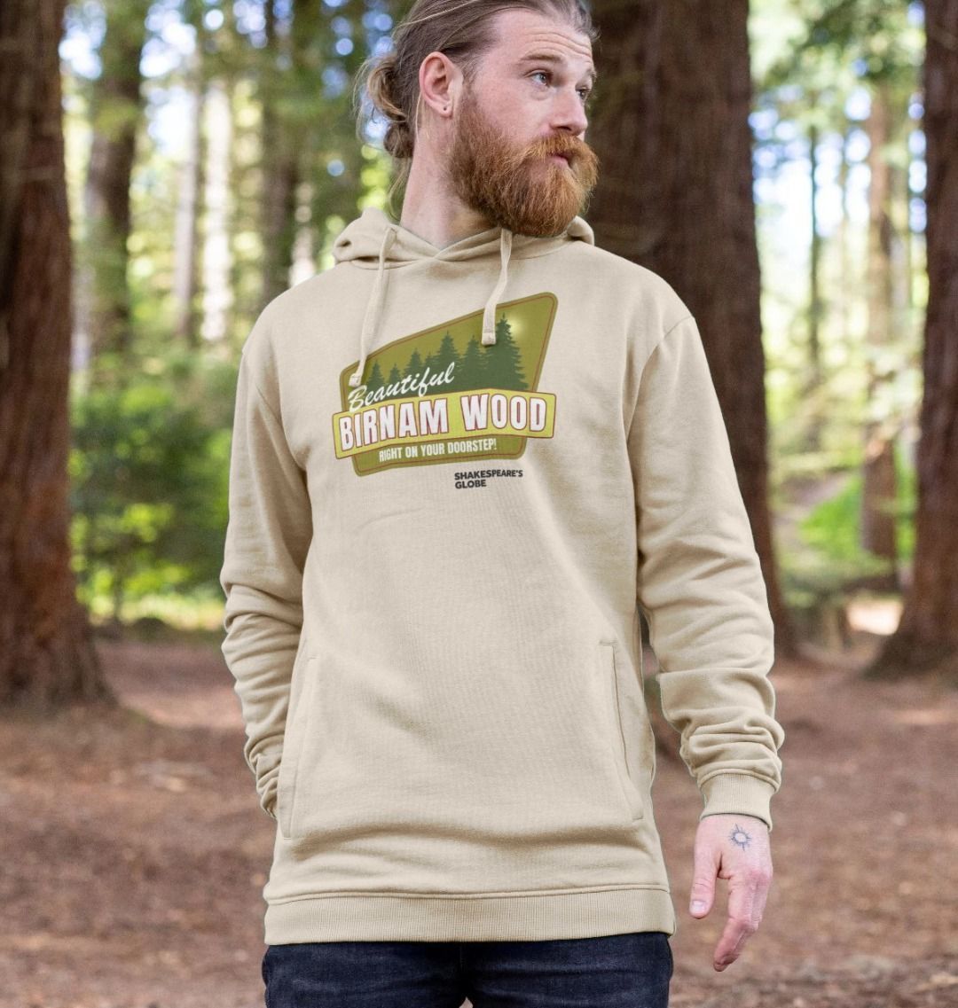 Beige hoodie with yellow and green vintage travel poster image of forest, with white graphic text over top