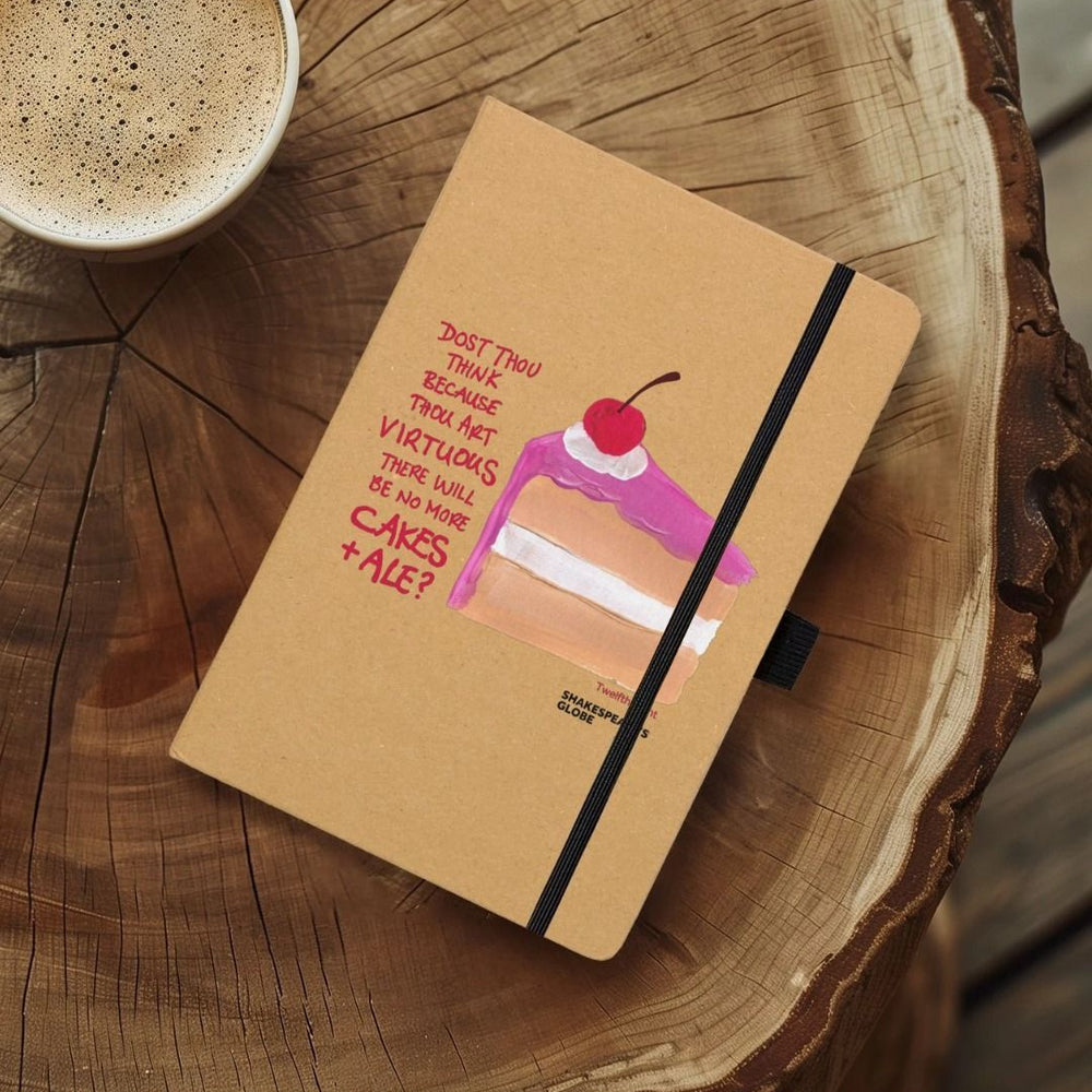 Kraft notebook with image of painted piece of vanilla cake with pink icing and red scratchy text on top, with black elastic closure