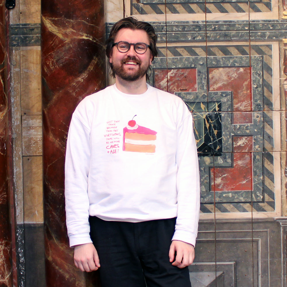 White coloured sweatshirt with image of pink iced piece of vanilla cake iced, with scratchy red text next to it