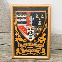 Framed coat of arms with 'Lord Robert Cecil' on a wooden surface