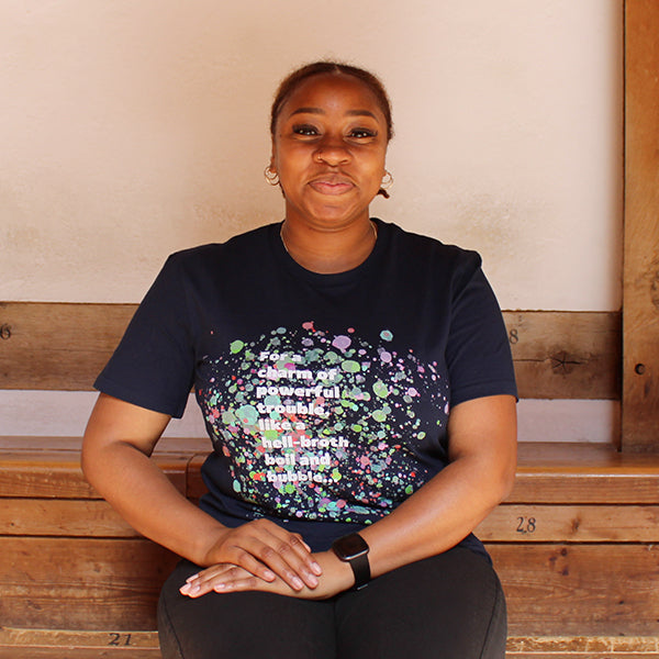 
                  
                    Navy blue t-shirt with pale blue, green, pink and purple bubbles behind white graphic text
                  
                