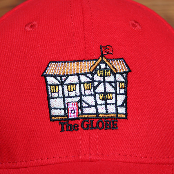 
                  
                    Red cotton baseball cap with curved bill and embroidered cartoon Shakespeare's Globe on front
                  
                