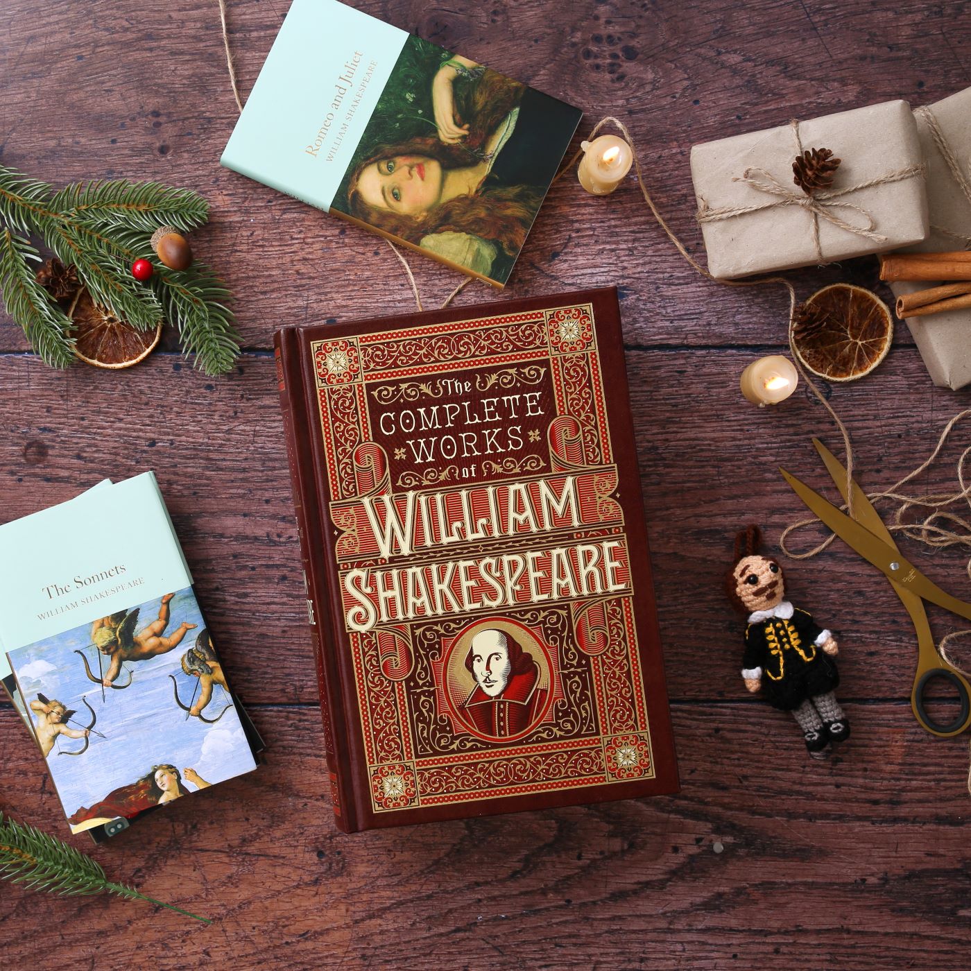 Hardback Shakespeare play texts lying on wood plank floor, with scissors, string, and wrapped brown packages