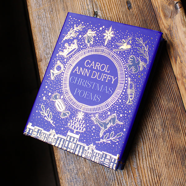 Book titled 'Christmas Poems' by Carol Ann Duffy on a wooden surface
