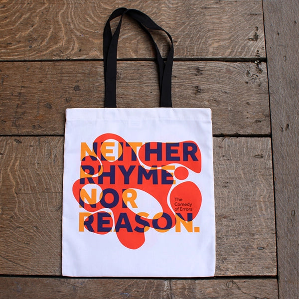 
                      
                        White cotton tote bag with 2 black handles, with orange bubbly graphic and purple and yellow text
                      
                    