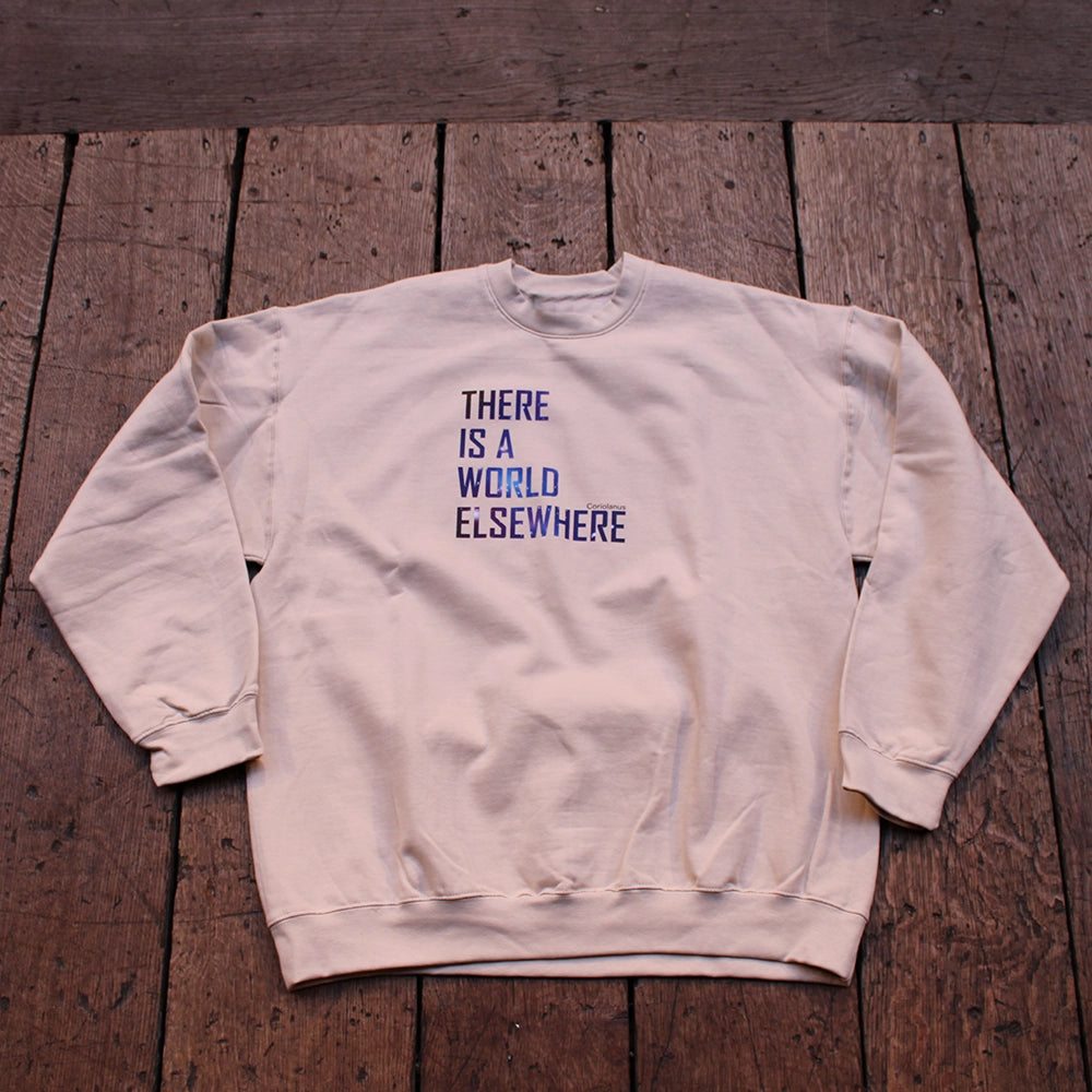 Sand coloured sweatshirt with graphic text featuring blue image of the cosmos in the lettering