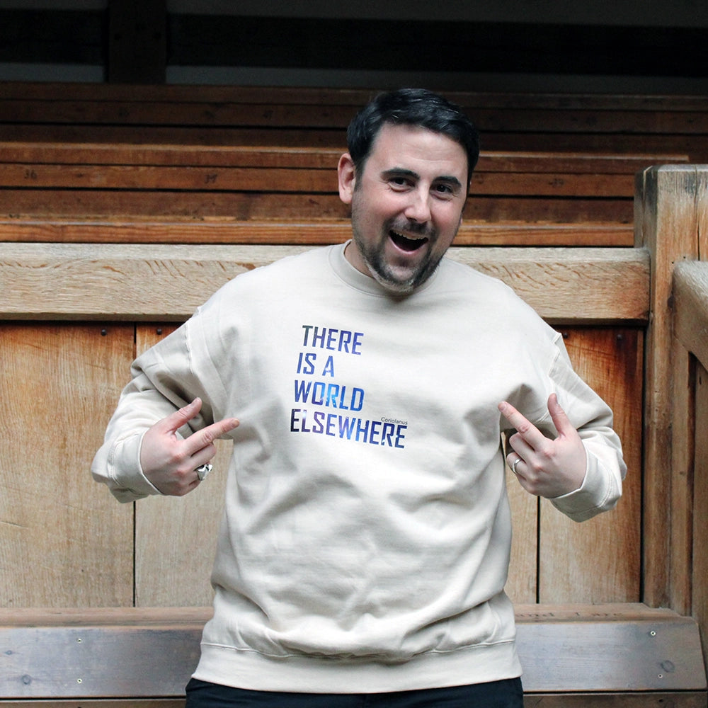 Sand coloured sweatshirt with graphic text featuring blue image of the cosmos in the lettering on male model