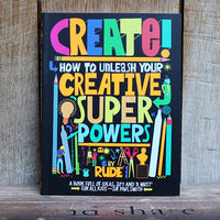 Book titled 'Create! How to Unleash Your Creative Super Powers' with colorful text and graphics on a wooden surface.