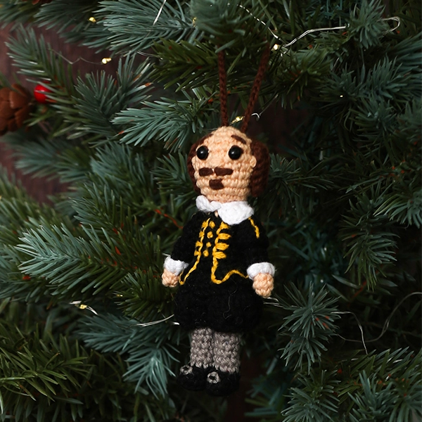 Crocheted Shakespeare decoration wearing a black doublet and hose with grey stockings on Christmas tree