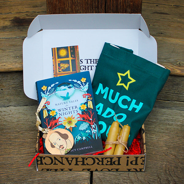 Box with a book, a bag, a bookmark, and a decoration on a wooden surface 