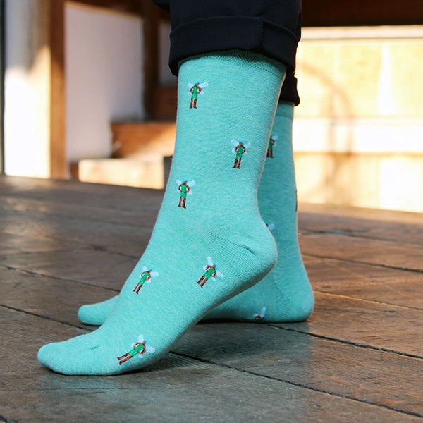 Teal cotton blend sock with repeating pattern of fairy from A Midsummer Night's dream, spaced an inch apart from one another