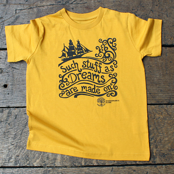 Yellow t-shirt with black ship and text design on a wooden surface