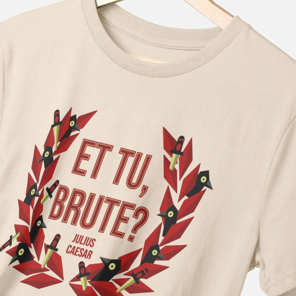 Beige t-shirt with centre front graphic of red laurel wreath with ravens and daggers within it, surrounding red graphic text