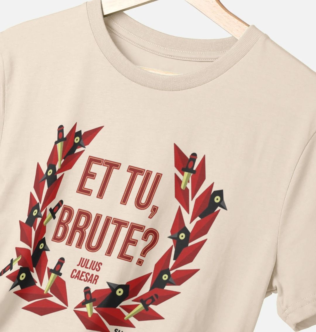 Beige t-shirt with centre front graphic of red laurel wreath with ravens and daggers within it, surrounding red graphic text