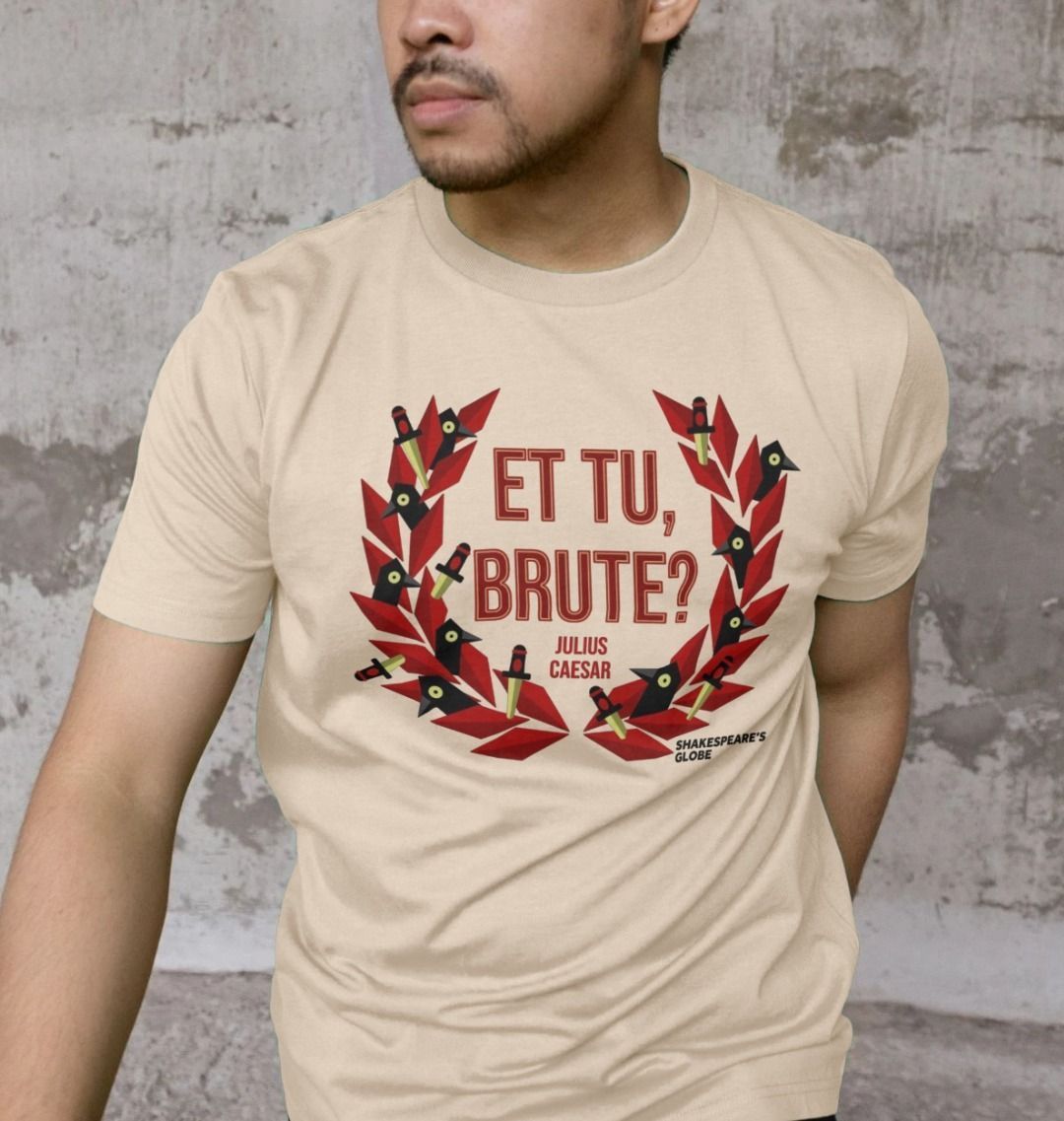 Beige t-shirt with centre front graphic of red laurel wreath with ravens and daggers within it, surrounding red graphic text