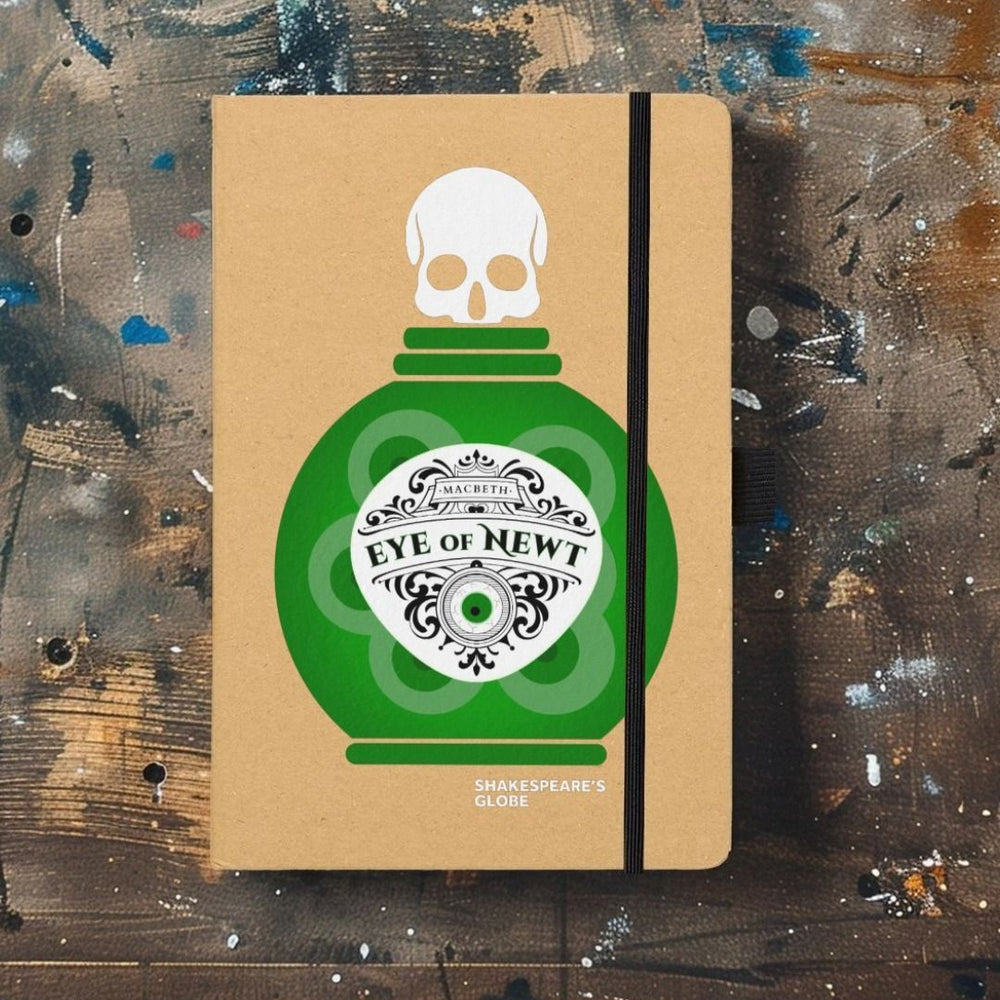 Kraft notebook with graphic depiction of green eye of newt bottle on the front, with black elastic closure on the side