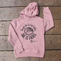 Pink hoodie with text and logo on a wooden surface