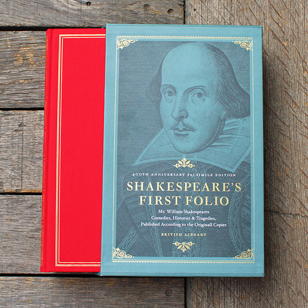 Red book and a blue slipcover with a portrait on the blue one, on a wooden surface.