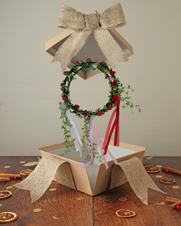 
                      
                        Fairy flower crowns with white, red or white flowers and ribbon in green leaf crown, popping out of kraft box with bow on wood base with Christmas decor
                      
                    