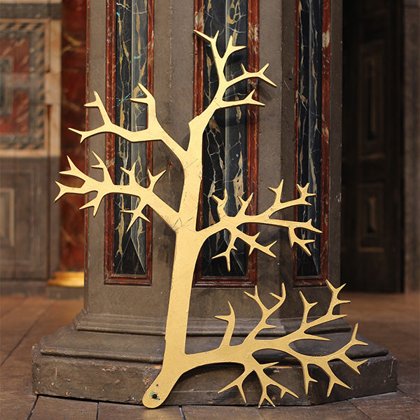 Plywood tree segment, painted gold, with jagged tree branches, from Much Ado About Nothing summer 2024 on the Globe Stage.