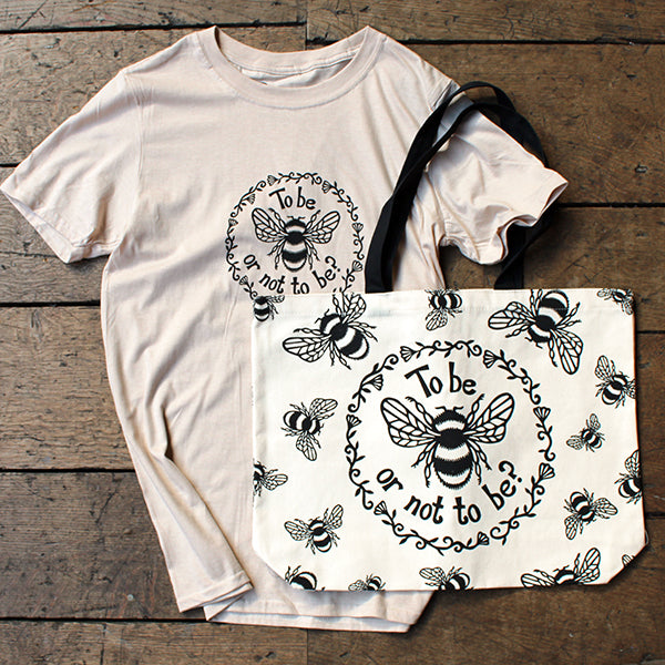Oat t-shirt and tote bag with bee design and text on a wooden surface
