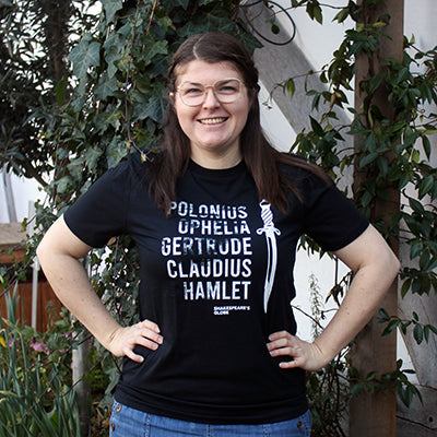 Black unsex t-shirt with white graphic text, in a line one on top of the other: Polonius, Ophelia, Gertrude, Claudius, Hamlet, with a dagger to the right