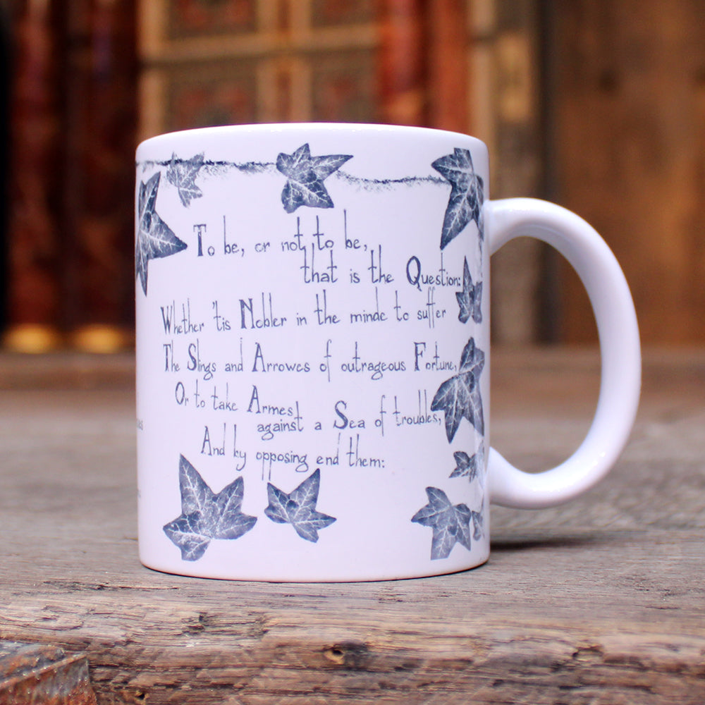 White mug with grey leafy graphics with scratchy 'to be' quotes text on either side