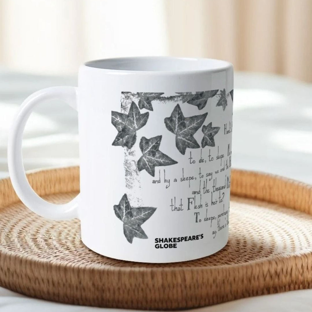 White mug with grey leafy graphics with scratchy 'to be' quotes text on either side